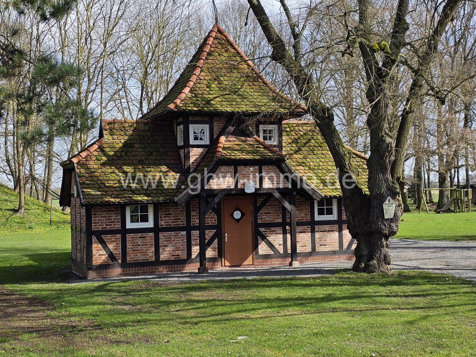 Nebengebäude mit Spielplatz im hinteren Bereich